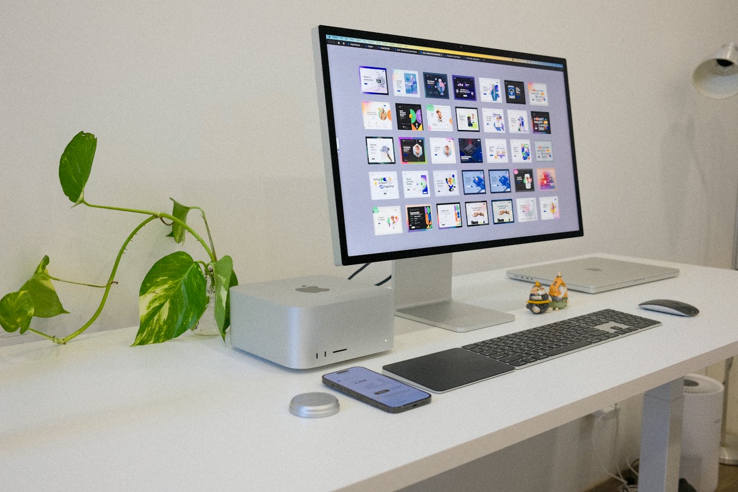 Modern office desk setup featuring computer hardware and a plant.